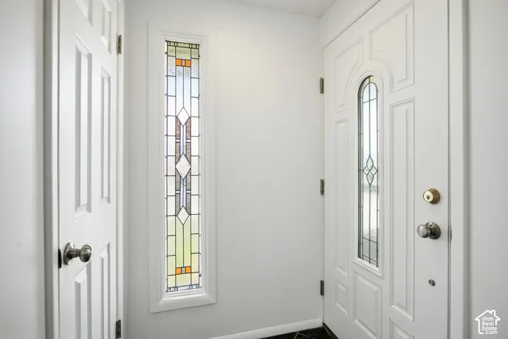 White paneled door with decorative glass inlay and polished brass hardware