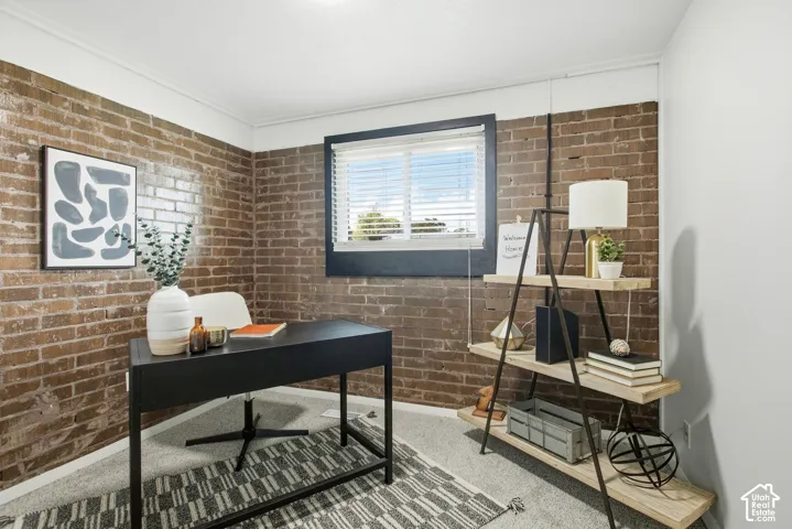 Exposed brick wall accents, window with blinds, recessed ceiling lighting, and a built-in shelving unit