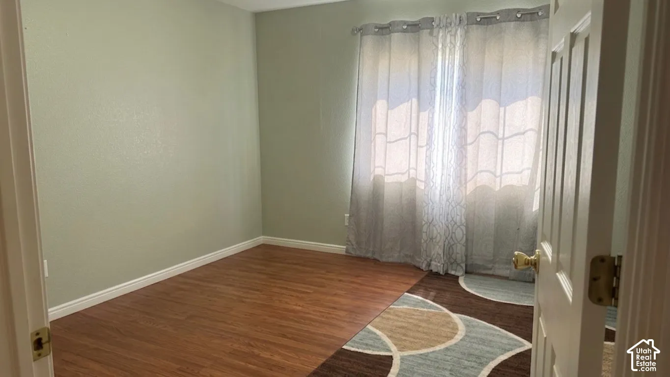 Wood-finish flooring with light green wall paint and white trim