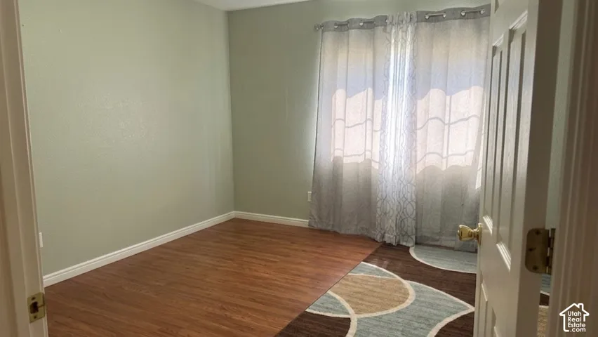 Wood-finish flooring with light green wall paint and white trim