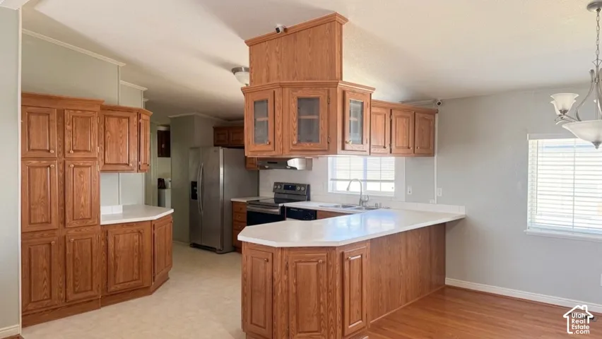 Wood-finish cabinetry with glass-front accents, white countertops, and a stainless-steel refrigerator