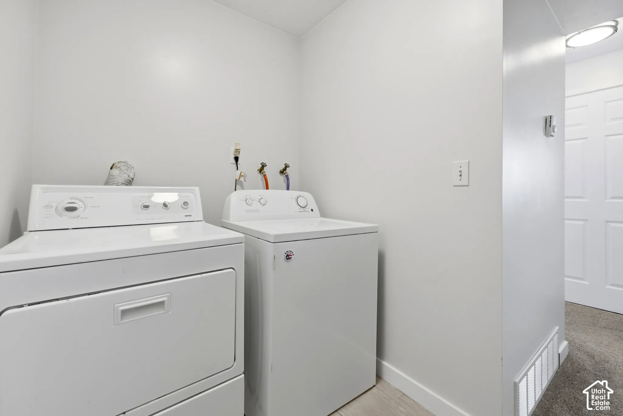 Dedicated laundry area with light wood-finish flooring