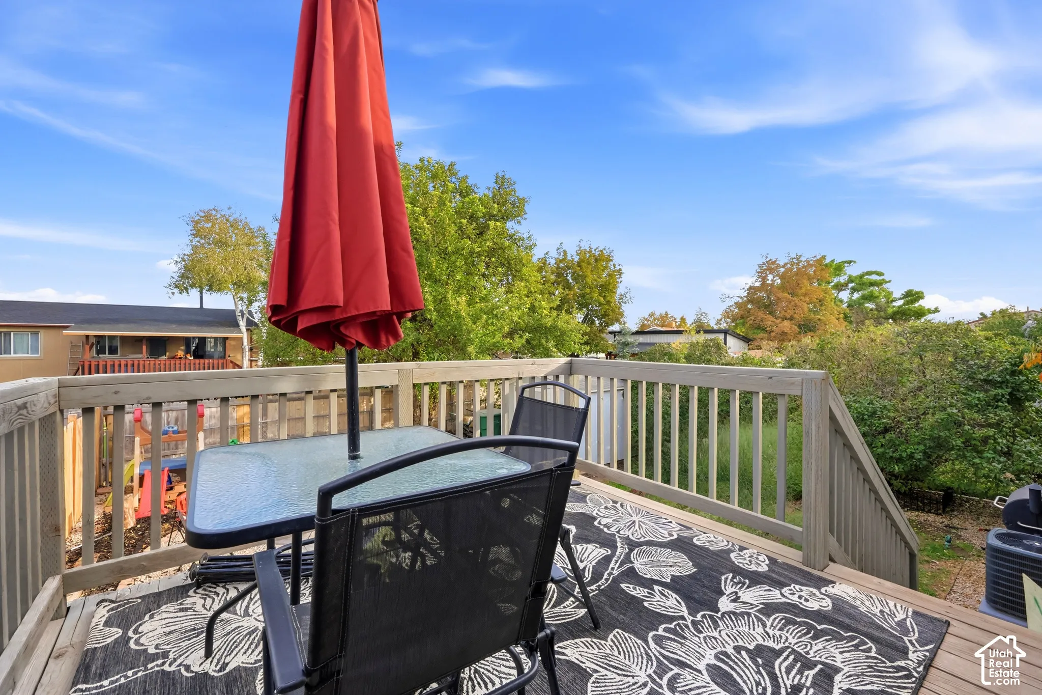 Outdoor deck featuring wood railing, wood-finish decking, and mature trees