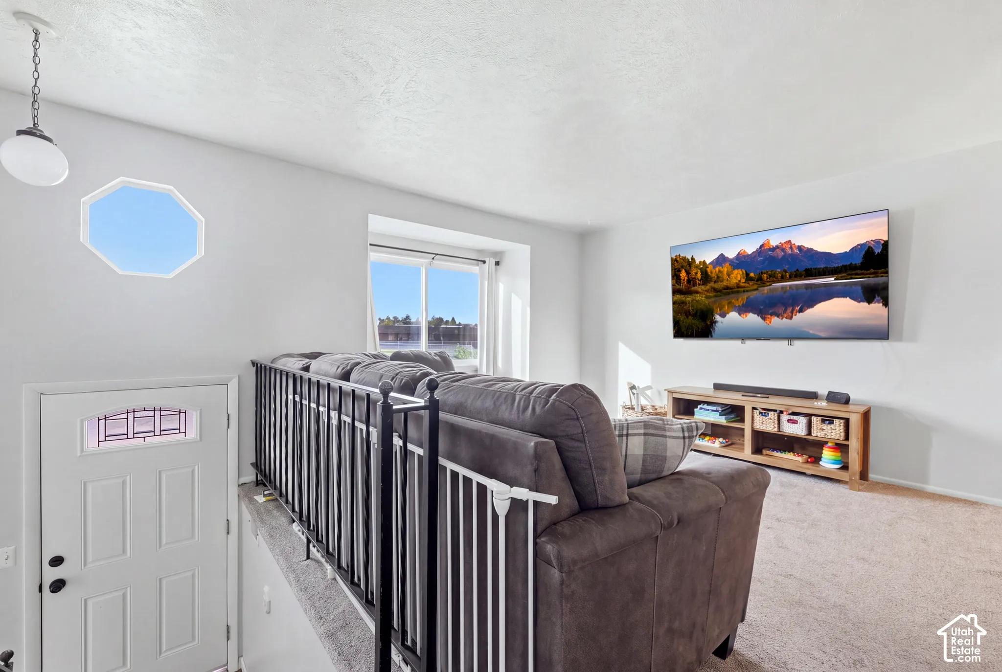 Octagonal window feature, white interior door with decorative glass insert, white walls, and light-toned carpeting