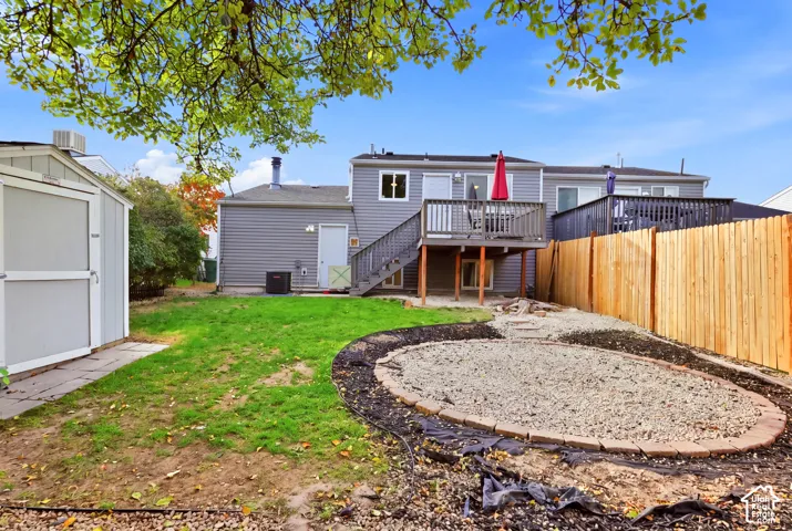 Expansive backyard featuring a manicured lawn, a gravel patio area with stone border, and a wood privacy fence