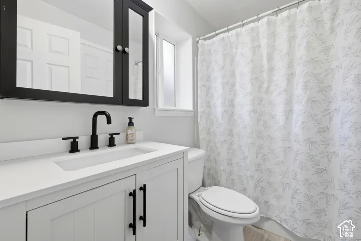 White vanity with panel-style doors and matte black hardware