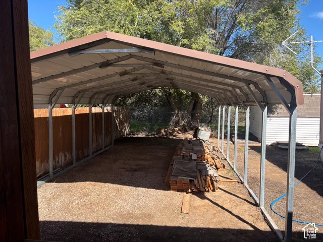 Covered carport structure with a metal roof and gravel flooring