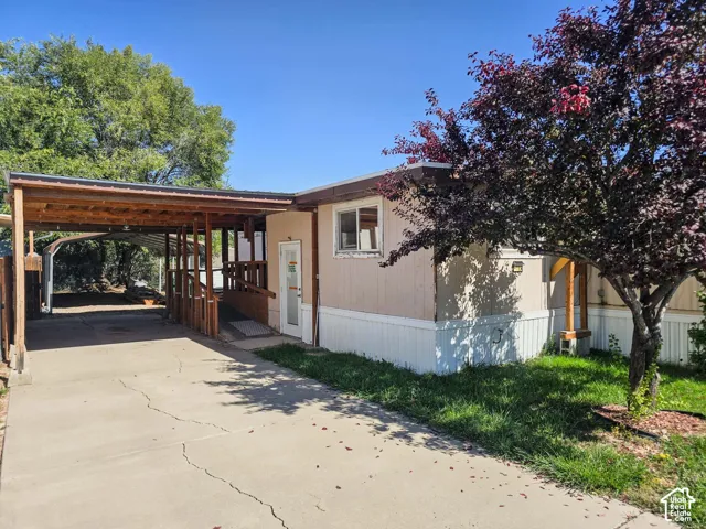 Carport with a wood frame and metal roof, leading to a ramped entry