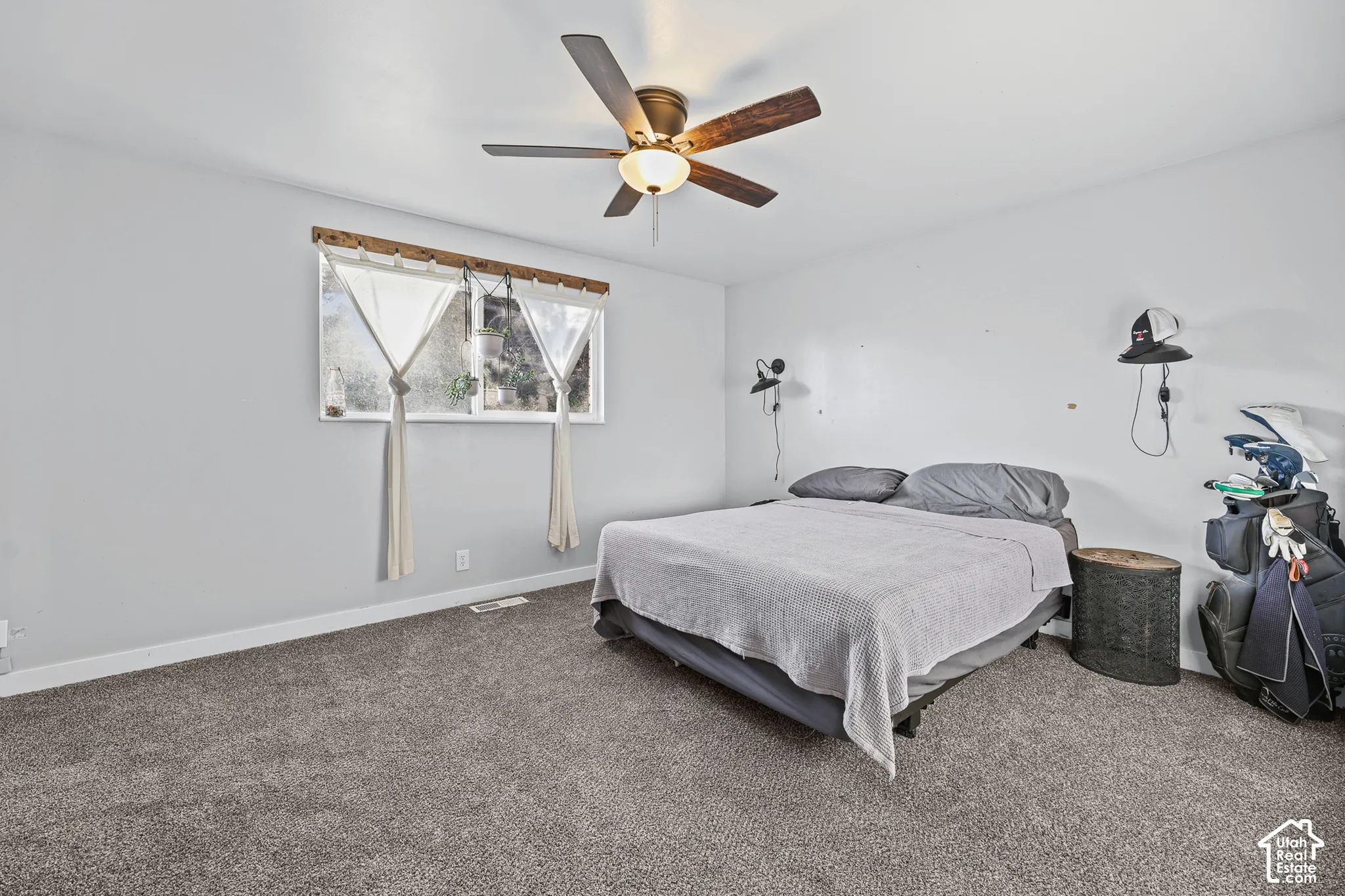 Spacious room with gray carpet, a window, and a ceiling fan with integrated lighting