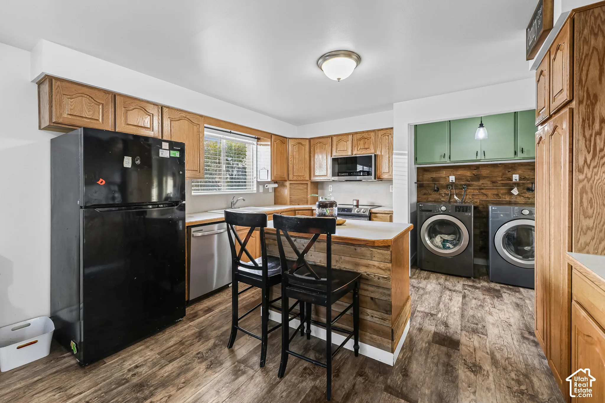 Wood-finish flooring throughout, wood grain cabinetry, and a kitchen island with a wood-paneled base