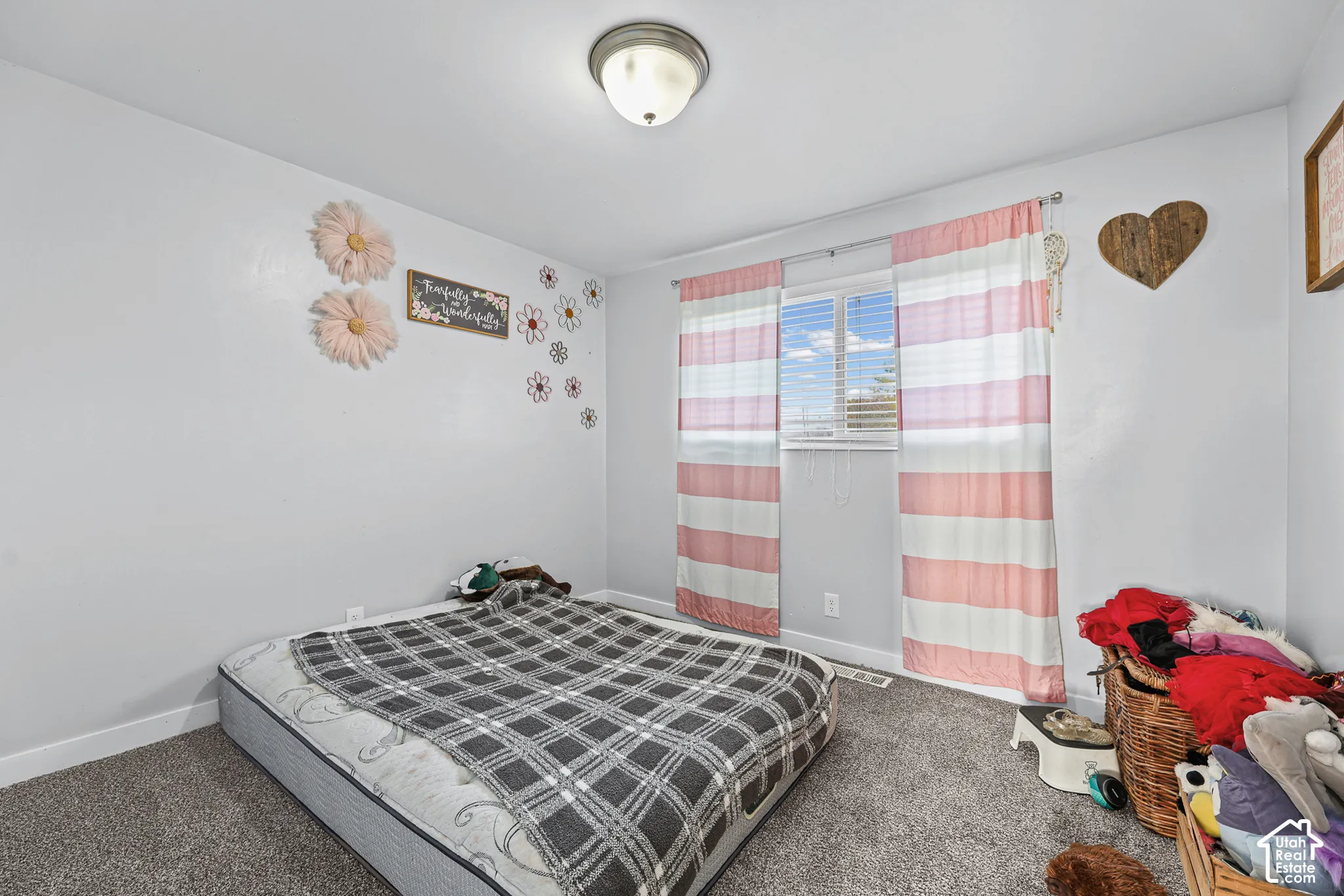 Wall-to-wall carpeting with a neutral finish, featuring a window with blinds, and an overhead flush-mount light fixture