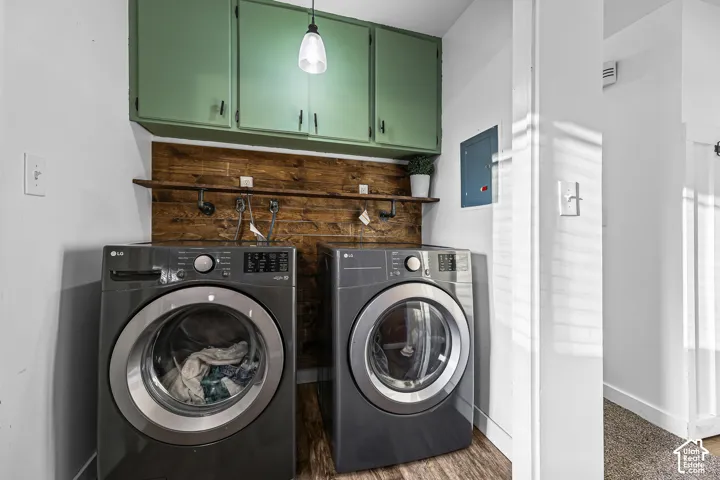 Green overhead cabinetry, wood-finish accent wall, and built-in shelving