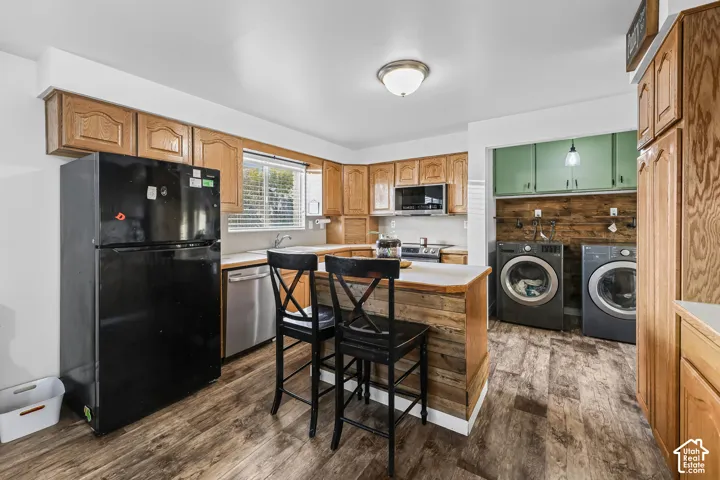 Wood-finish flooring throughout, wood grain cabinetry, and a kitchen island with a wood-paneled base