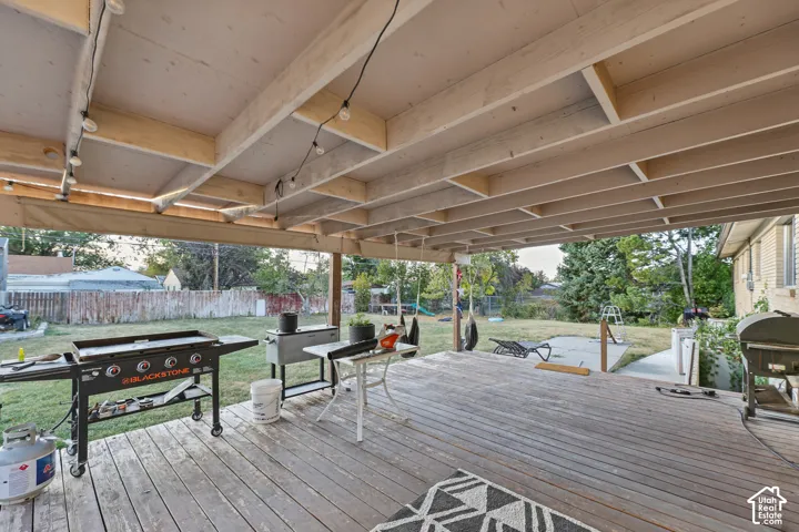 Expansive covered deck featuring string lighting and wood flooring
