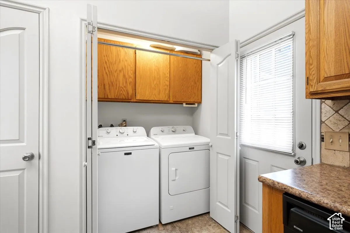 Laundry area featuring wood-finish cabinetry and a clothes hanging rod