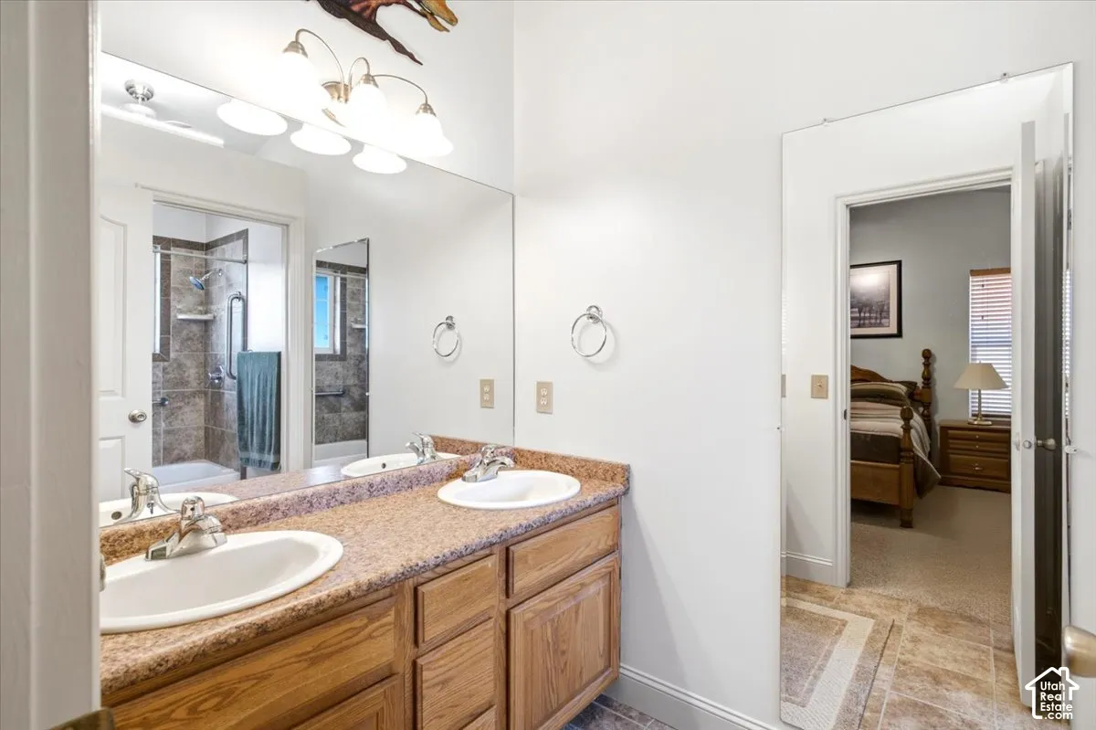 Dual vanity with integrated sinks, wood-finish cabinetry, and a full-width wall mirror