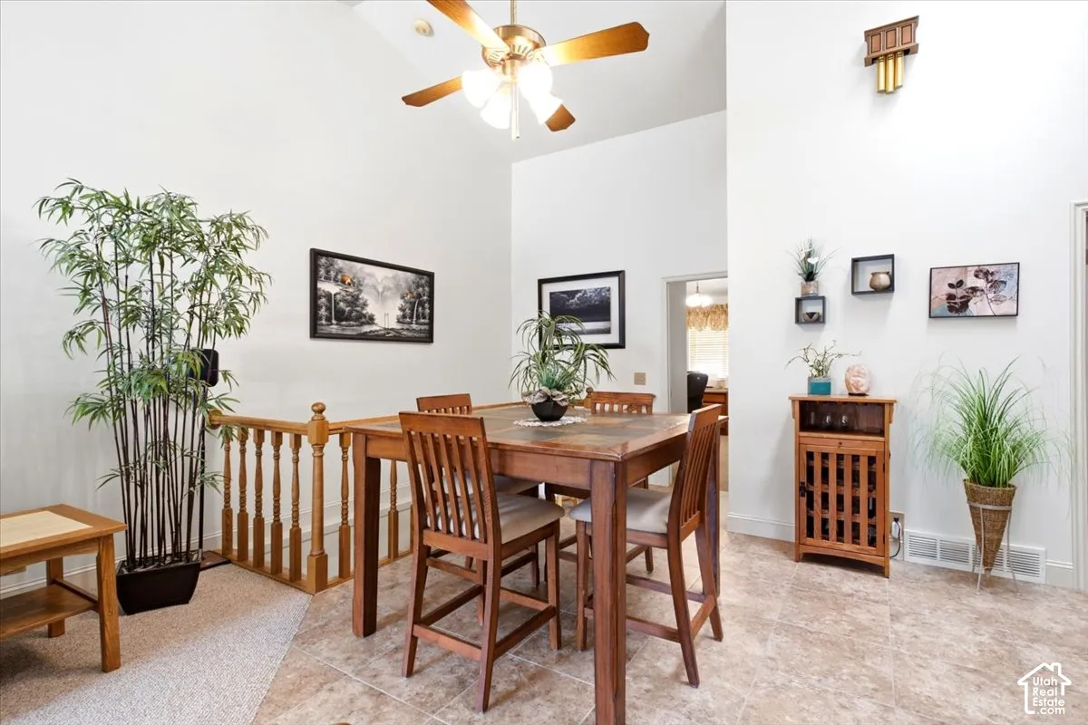 Vaulted ceilings with a ceiling fan, recessed lighting, wood railing, and tiled flooring