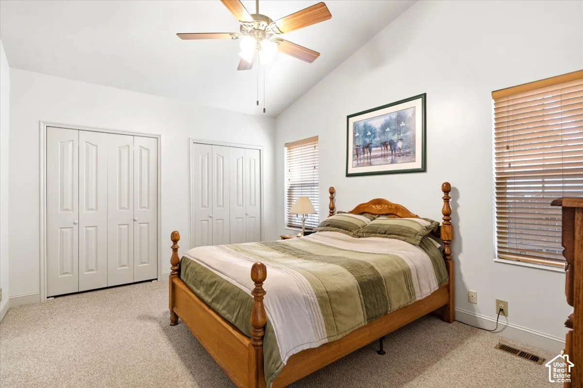 Vaulted ceiling, ceiling fan, two sets of bi-fold closet doors, wall-to-wall carpeting, and window blinds