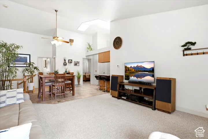 Vaulted ceiling with skylight, recessed lighting, and ceiling fan