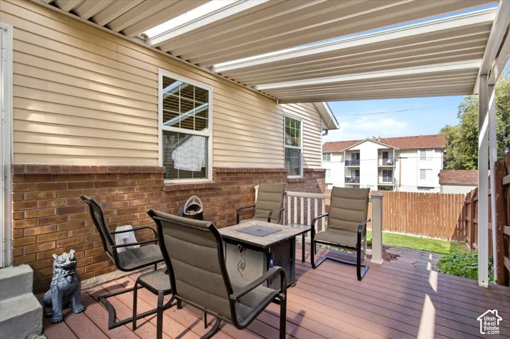 Expansive outdoor deck featuring a fixed patio cover, composite decking, and a privacy fence
