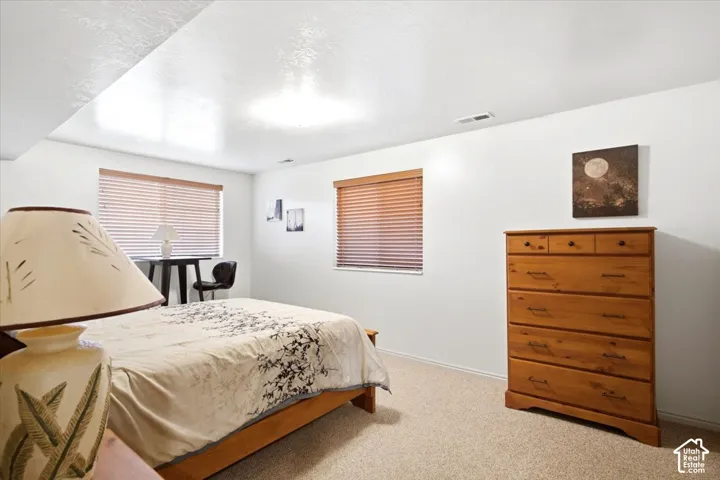 Recessed lighting, wood-finish window blinds, and light-toned carpeting