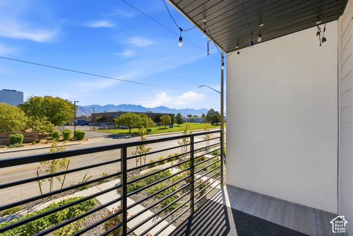 Balcony featuring a black metal railing and attached string lights