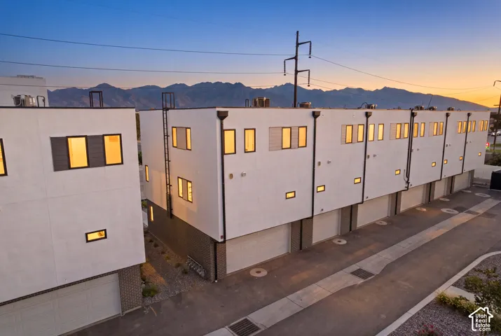 Modern multi-level townhome architecture with a white stucco facade
