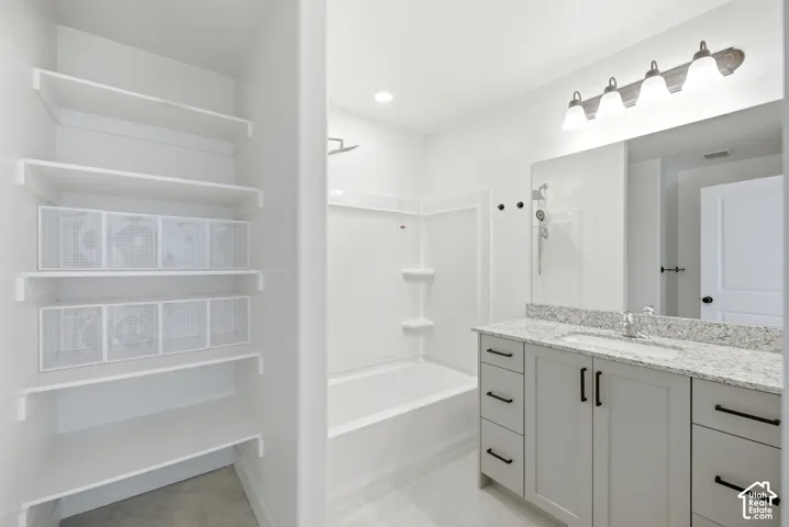Vanity with granite-style countertop, undermount sink, and matte black hardware