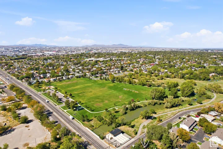 Expansive green space and surrounding mature trees with a waterway