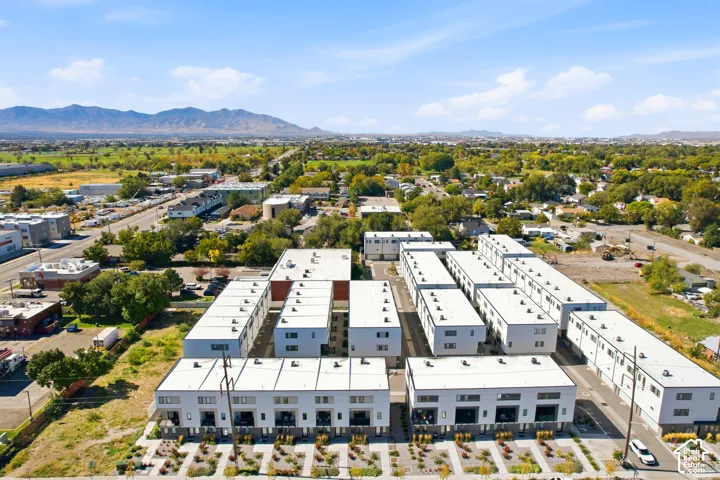 Modern multi-story buildings featuring white exteriors, flat roofs, and integrated balconies
