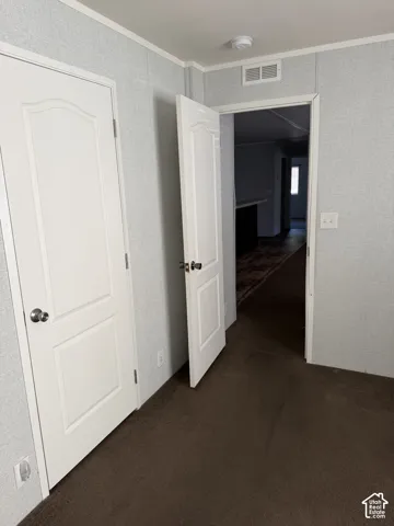 Textured wall panels with white trim, interior doors with satin nickel hardware, and brown carpeting