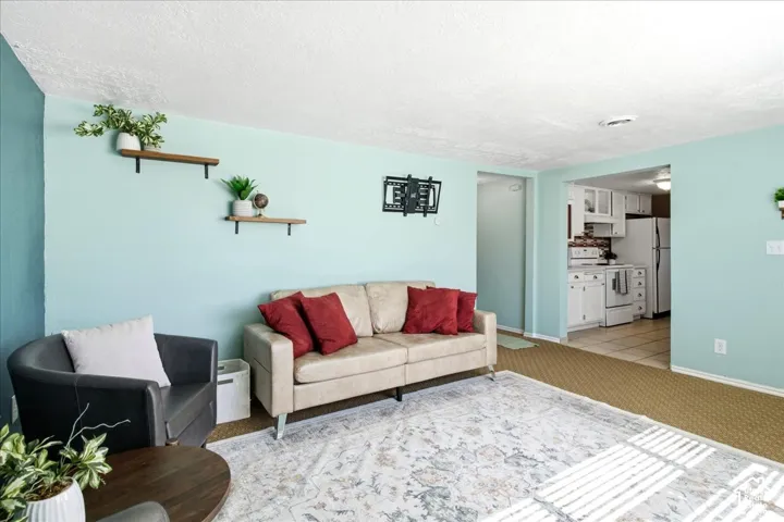 Recessed lighting, wood-finish shelving, and a kitchen entry