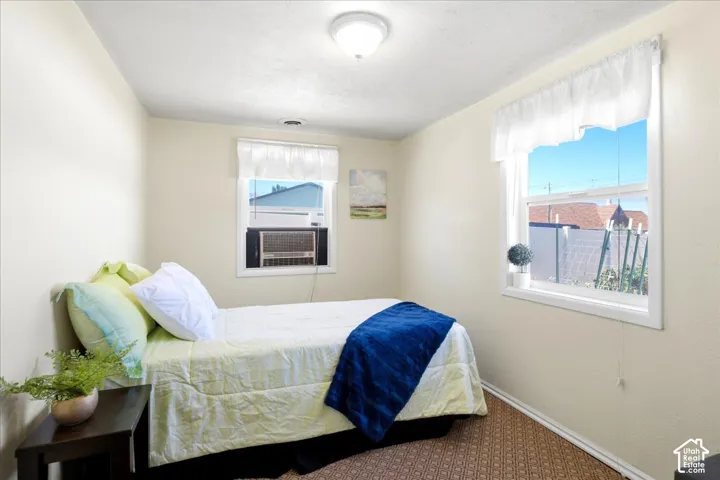 Recessed overhead lighting, textured ceiling, wall-mounted air conditioning unit, white-framed windows