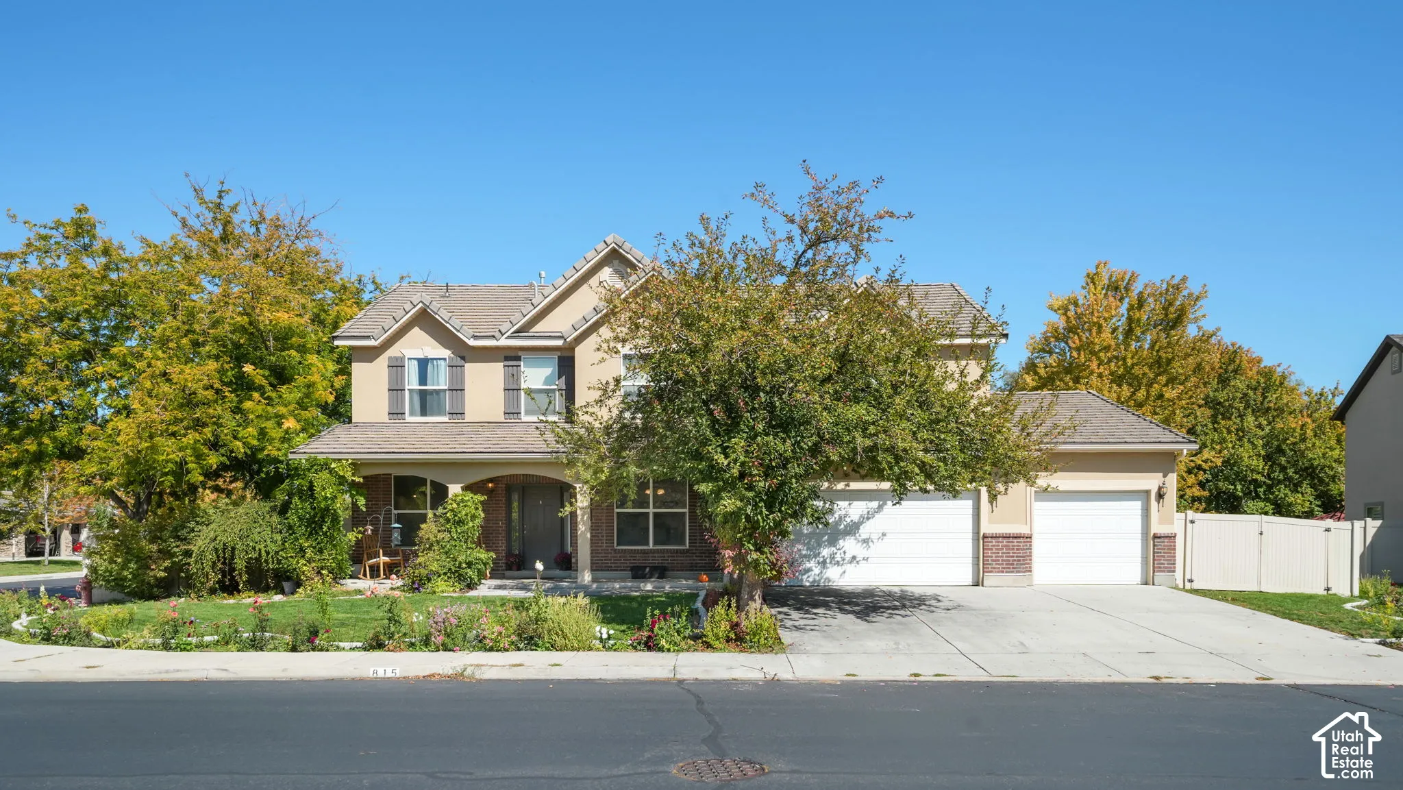 Two-story stucco exterior with brick accents, arched entry, and a two-car garage