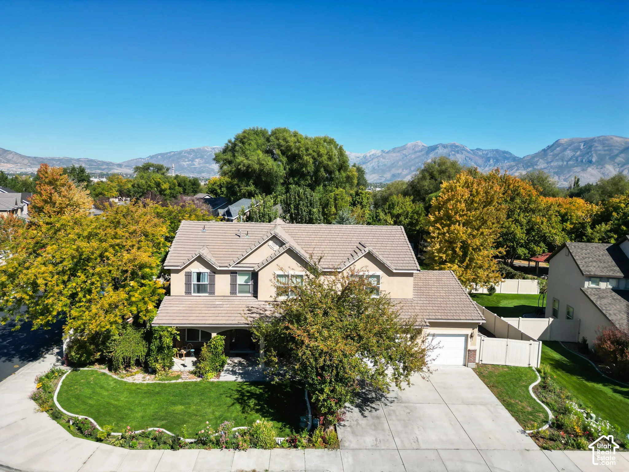 Two-story residence with a light-toned stucco exterior and a tiled roof