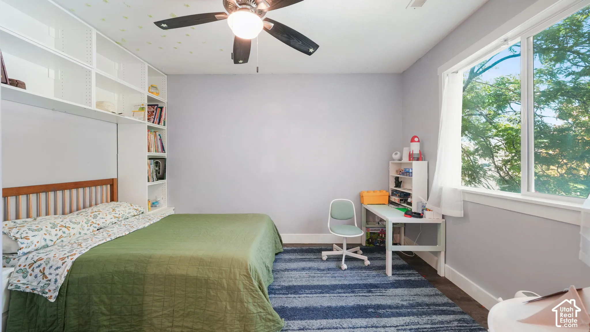 Built-in shelving, ceiling fan, and a large window