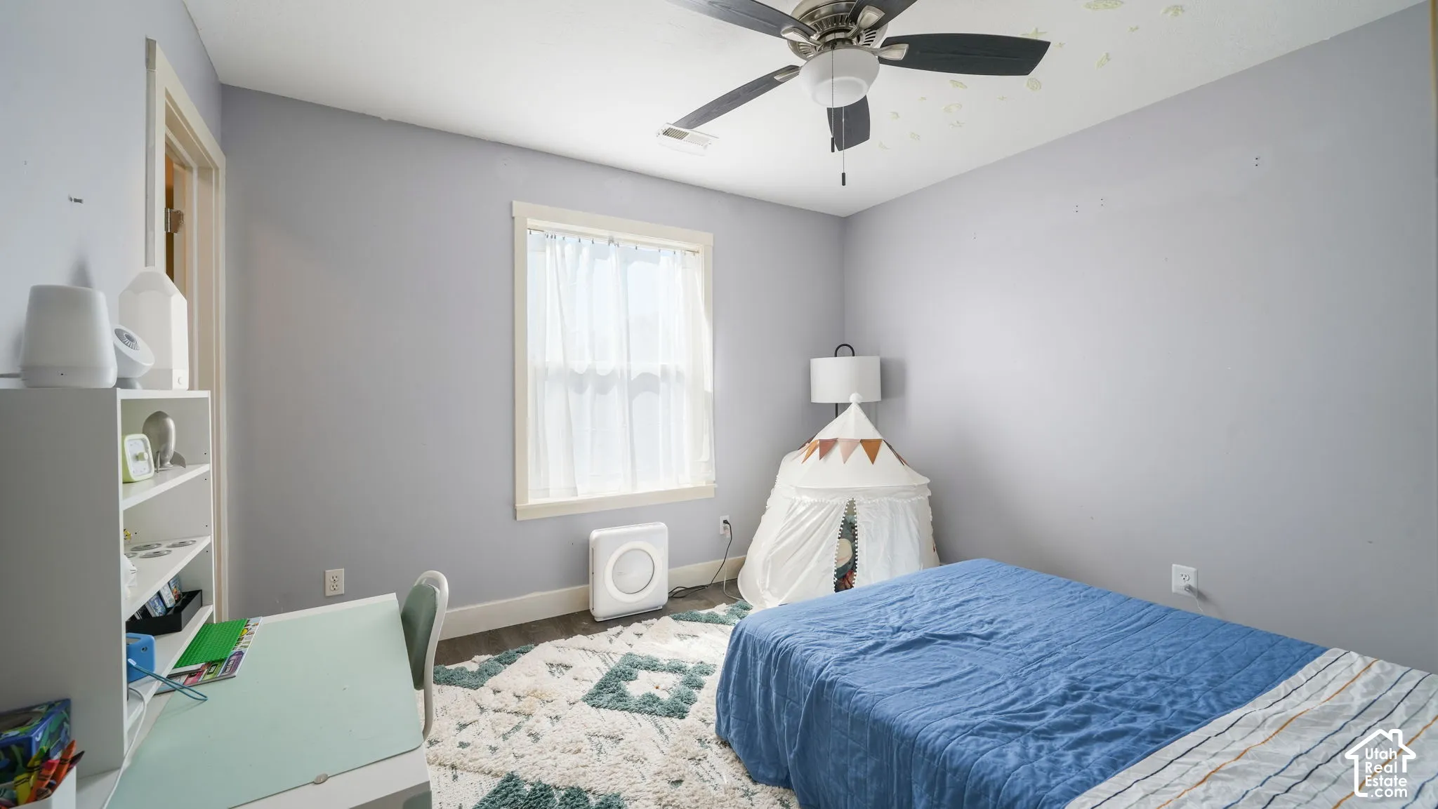 Ceiling fan fixture, window with trim, wood-finish flooring, built-in shelving, wall-mounted light fixture