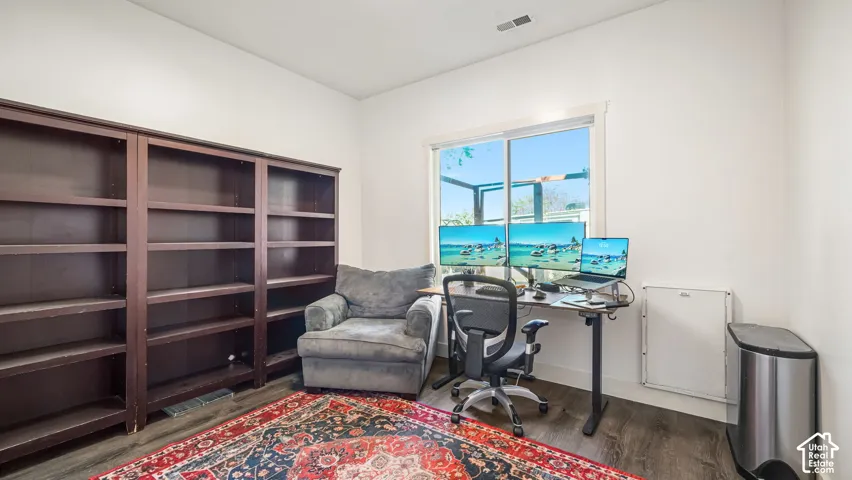 Wood-finish flooring, built-in shelving, white walls, and a large window
