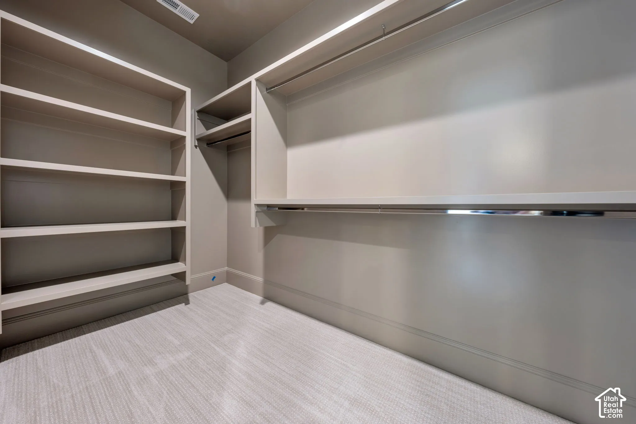 Built-in shelving, integrated hanging rods, and neutral carpeting