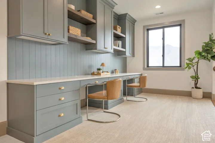 Built-in desk area with shaker-style cabinetry, open shelving, and a light-toned countertop