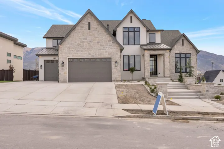 Striking stone and stucco exterior with peaked gable rooflines and multi-pane windows