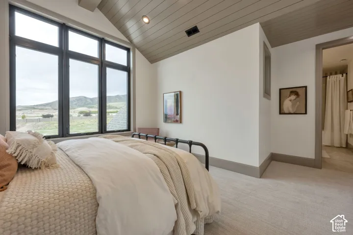 Vaulted ceiling with wood-finish paneling, recessed lighting, and expansive multi-pane windows
