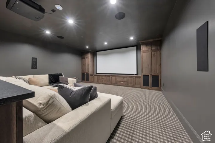 Built-in entertainment center featuring a large screen, integrated speakers, and custom wood cabinetry