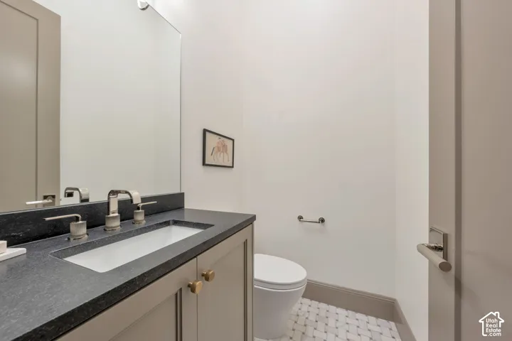 Integrated vanity with an undermount sink, a dark stone-finish countertop, and a chrome faucet