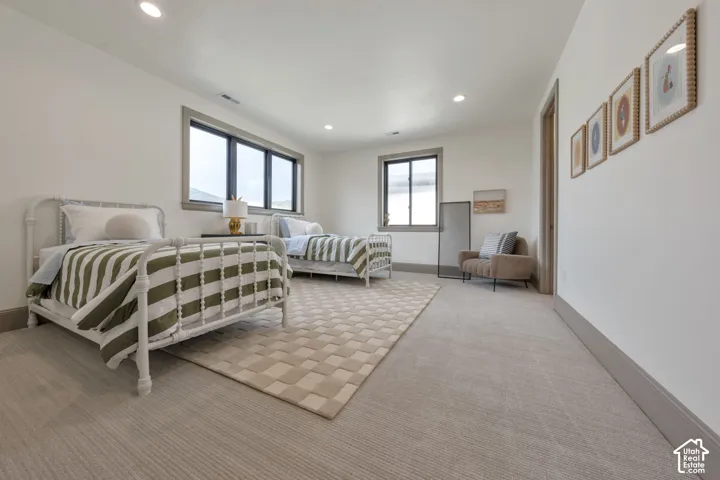 Recessed ceiling lighting, light gray wall paint, and gray carpet flooring