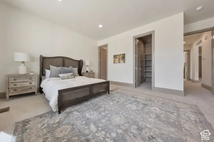 Recessed lighting, light-toned carpeting, built-in shelving, and neutral wall tones