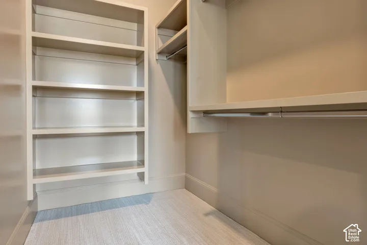 Built-in shelving unit, integrated clothes hanging rods, and neutral-toned wall paint
