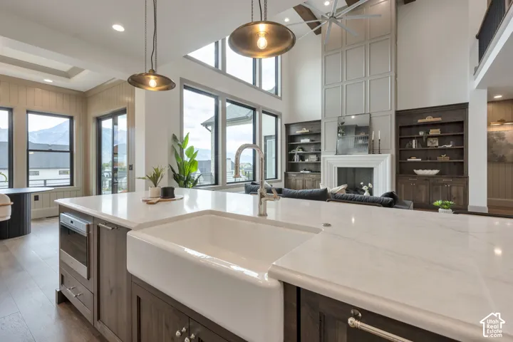 Kitchen island with a farmhouse sink, stainless steel faucet, and light-toned countertop