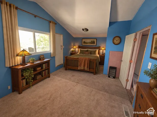 Vaulted ceiling, wall-to-wall carpeting, wood-finish bed frame, wood-finish side tables, and a dual-pane window