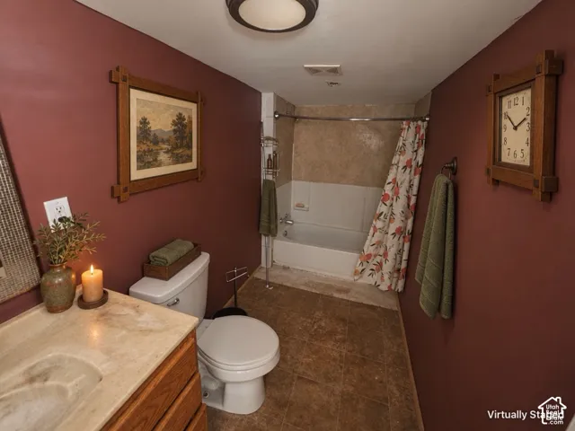 Tub and shower combination with a curved shower rod, a built-in vanity with an integrated sink, wood-finish flooring, and a flush-mount ceiling light